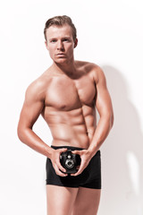 Male fitness underwear model with vintage photo camera. Wearing