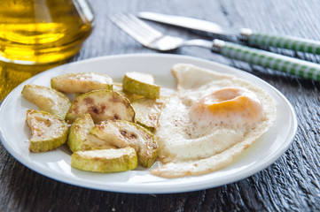 fried eggs and chopped zucchini with parsley on the plate