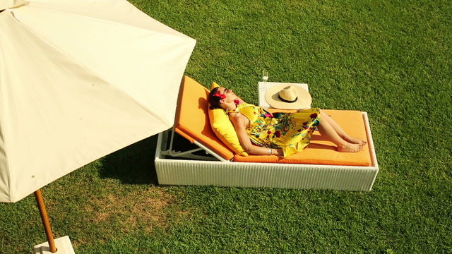 Woman sleeping on lounger bed in garden