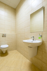 Fototapeta na wymiar Small restroom in public building, clean modern toilet or wc in office or house