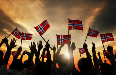 Group of People Waving Norwegian Flags in Back Lit