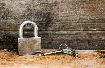 Key and lock on wooden background