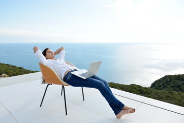 relaxed young woman at home working on laptop