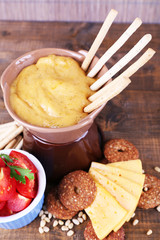 Fondue, slices of cheese, tomatoes and biscuits