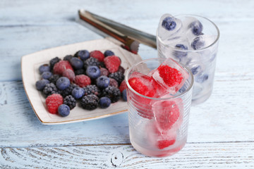 Frozen berries and ice cubes with mint leaves, raspberry and