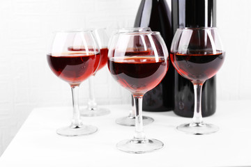 Glasses and wine bottle on table in room