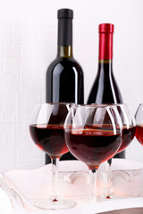 Glasses and wine bottle on tray in room
