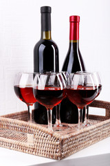 Glasses and wine bottle on tray in room