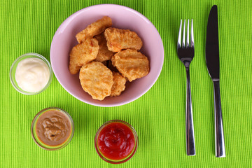 Chicken nuggets with sauces on table close-up