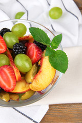 fresh tasty fruit salad on wooden table