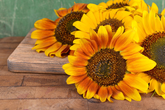 Beautiful sunflowers on table on wooden background
