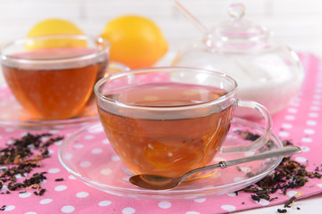 Cups of tea on table on brick wall background