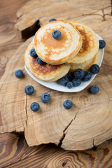 Homemade fritters with blueberries over rustic wooden surface