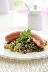 Grünkohl mit Wurst und Kartoffeln auf Teller