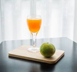 Glass of freshly pressed orange juice with orange