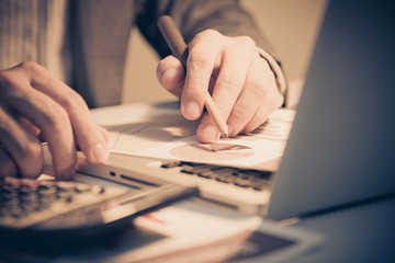 Businessman analyzing investment charts with laptop. Accounting