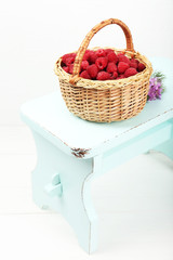 Fototapeta na wymiar Fresh raspberries in basket on white wall background