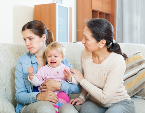 Mature woman comforting a young mother with baby