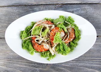 Fresh prawns with spaghetti, olives and lettuce in a white oval