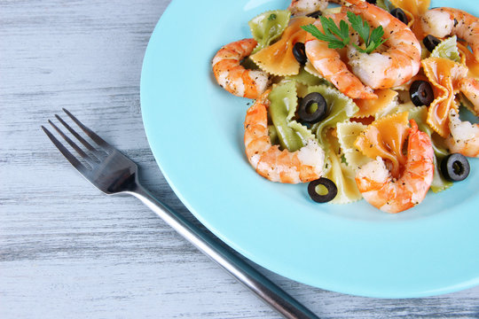 Fresh prawns with coloured macaroni, olives and parsley in a