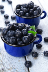Delicious blueberries in cups on table close-up
