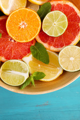 Different sliced juicy citrus fruits in bowl