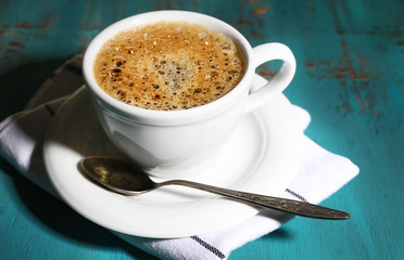 Cup of coffee on color wooden background