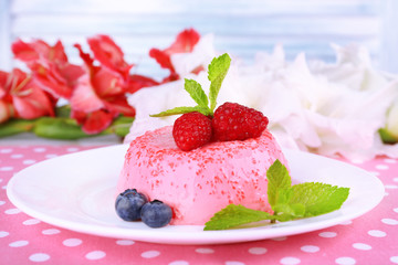 Round shaped cake with berries on plate on polka dot table