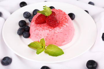Round shaped cake with berries on plate on table cloth
