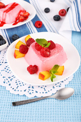 Cakes with fruit and berries on plate on lace napkin