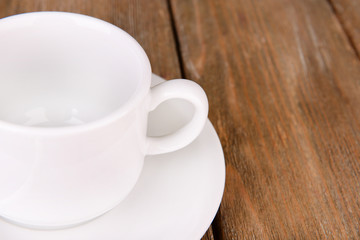 Empty cup with tea spoon on wooden background