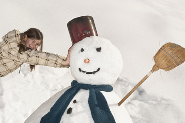  Mädchen auf Schneemann gelehnt