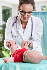 Pediatrician examining little baby