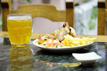 The image of meat with a garnish and mug with a beer