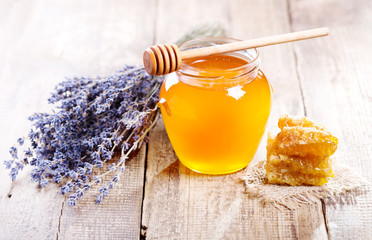 jar of honey with honeycomb and lavander flowers