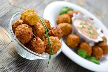 Falafels ready to eat on a plate with sauce and herbs
