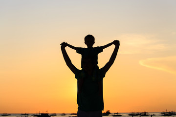 father and son on sunset beach