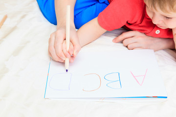 hands of mother and child writing letters