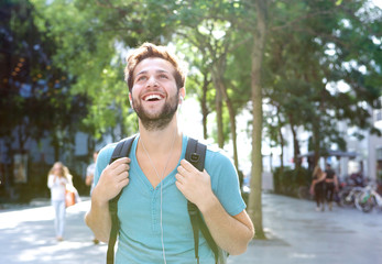 Fototapeta premium Portrait of a handsome young man walking outdoors with backpack
