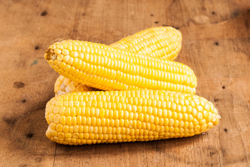 Grains of ripe corn on wood.