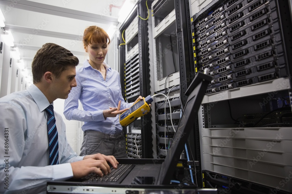 Aufkleber team of technicians using digital cable analyser on servers