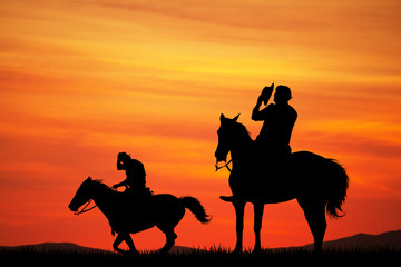 men on horseback at sunset