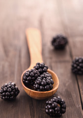 Fototapeta na wymiar Blackberries with spoon on wooden background