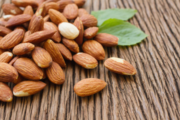 Almonds  with leaf on wooden background