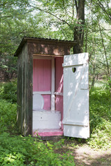 Old wooden outdoors toilet in summer.