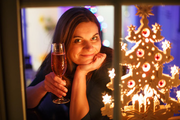 Portrait of young woman through window celebrating New Year's Ev