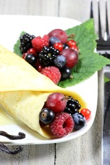 Pfannkuchen mit frischen Beeren auf Holztisch