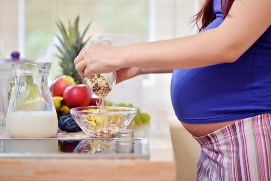 pregnant woman prepering meal
