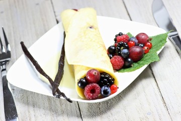Pfannkuchen mit frischen Beeren auf Holztisch