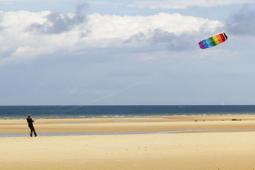 Man playing with a kite at the beach